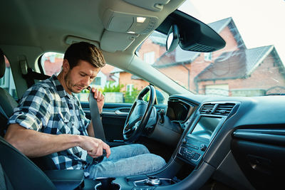 Side view of man driving car
