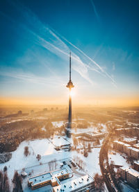 Aerial view of silhouette tower against sky in city during winter