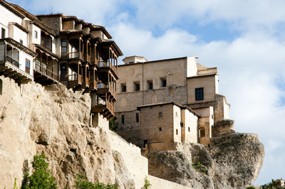 Low angle view of buildings against cloudy sky