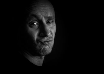 Portrait of man against black background