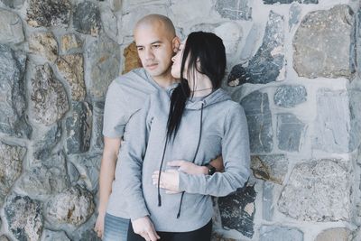 Couple romancing against stone wall