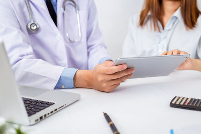 Midsection of woman using mobile phone