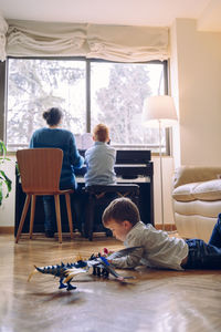 Boy playing with toys on floor at home