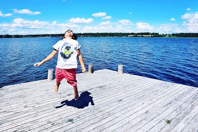 Full length rear view of man in lake against sky