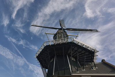 Low angle view of traditional windmill against sky