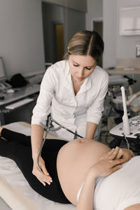 Young female doctor examining patient at clinic