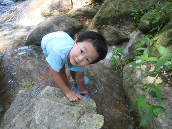 High angle portrait of boy on rock