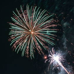Low angle view of firework display at night
