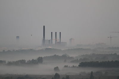 Smoke stacks in factory against sky