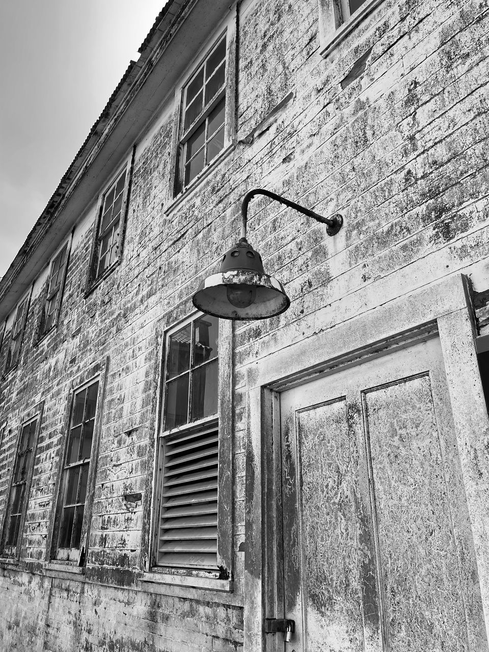architecture, built structure, building exterior, white, window, house, black and white, monochrome, building, history, urban area, monochrome photography, low angle view, no people, street, wall, old, black, day, road, residential district, wall - building feature, abandoned, outdoors, sky, facade, nature, door, entrance, city, alley, rundown, the past