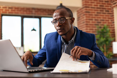 Businessman analyzing document at office