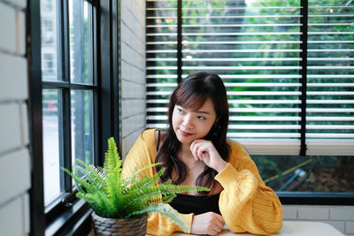 Portrait of smiling woman in glass window