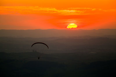 Scenic view of silhouette landscape against orange sky