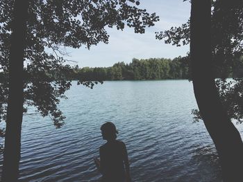 Rear view of man standing by lake