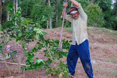 Midsection of woman standing by plants on field