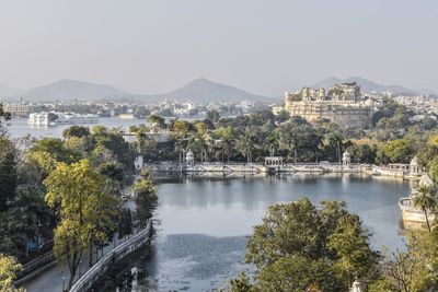 Udaipur city palace at waterfront against sky