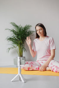 Young woman sitting on sofa at home