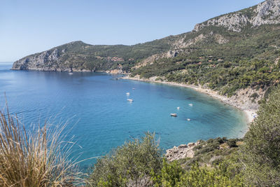 Scenic view of sea and mountains against clear sky