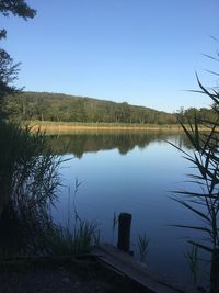 Scenic view of lake against clear blue sky