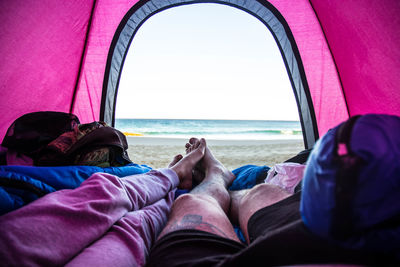 Low section of people in tent against sky