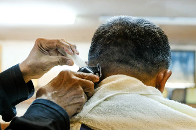 Close-up of man getting haircut at barber shop