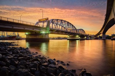 Bridge over river against sky during sunset