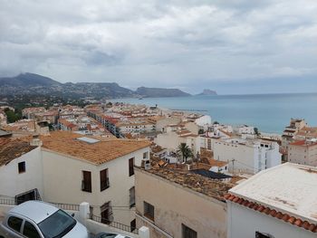 High angle view of townscape by sea against sky