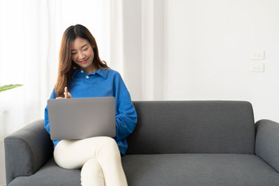 Young woman using laptop at home