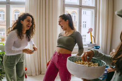 Playful young women enjoying weekend together at home