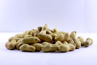 Close-up of coffee beans on table against white background