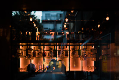Illuminated restaurant by building at dusk
