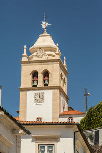 Low angle view of bell tower against clear blue sky