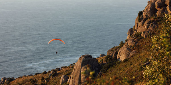 People paragliding over sea