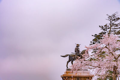 Low angle view of bird statue against sky