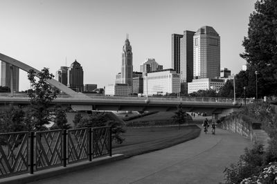 Bridge over canal amidst buildings against clear sky