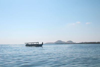 Boat sailing in sea against sky