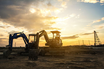 Earth mover at construction site during sunset