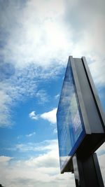 Low angle view of modern building against cloudy sky