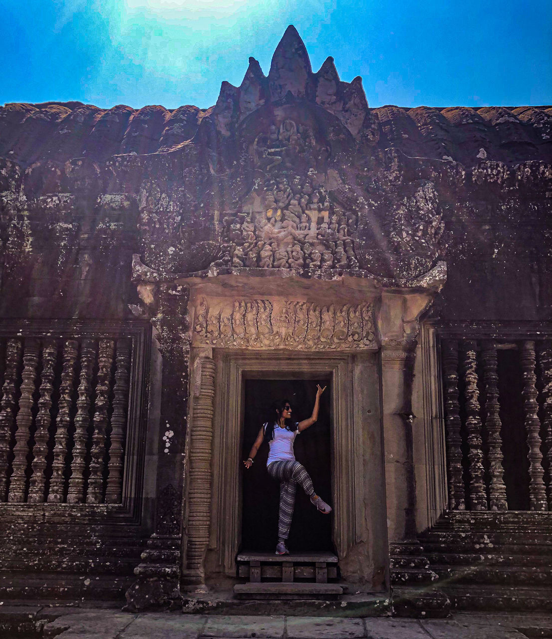 LOW ANGLE VIEW OF WOMAN STANDING ON A BUILDING