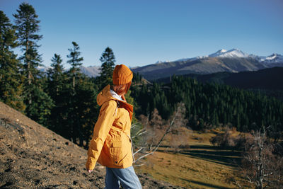 Rear view of woman standing against mountain