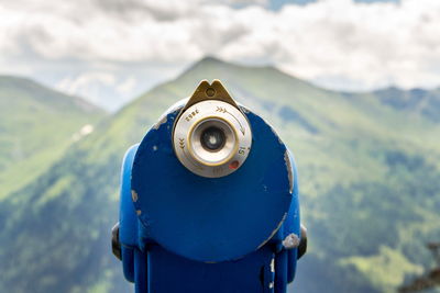 Close-up of coin-operated binoculars against mountain range