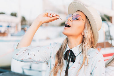 Close-up of woman wearing hat eating fruit outdoors