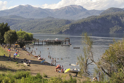 High angle view of people on lake by mountains