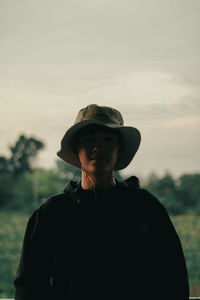 Portrait of young man standing against sky