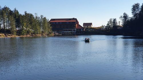 Scenic view of lake by buildings against sky