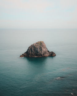 Scenic view of rock formation in sea against sky