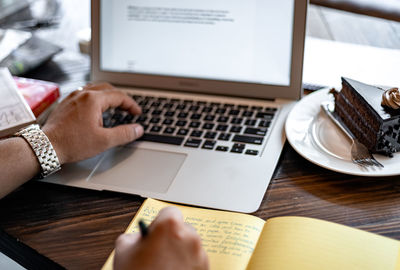 Midsection of man using laptop on table