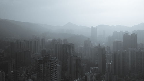 Aerial view of cityscape against sky during foggy weather