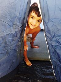 Portrait of cute boy smiling while inside tent