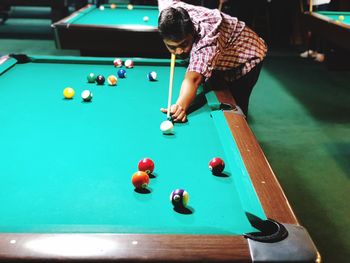 High angle view of young man playing pool ball